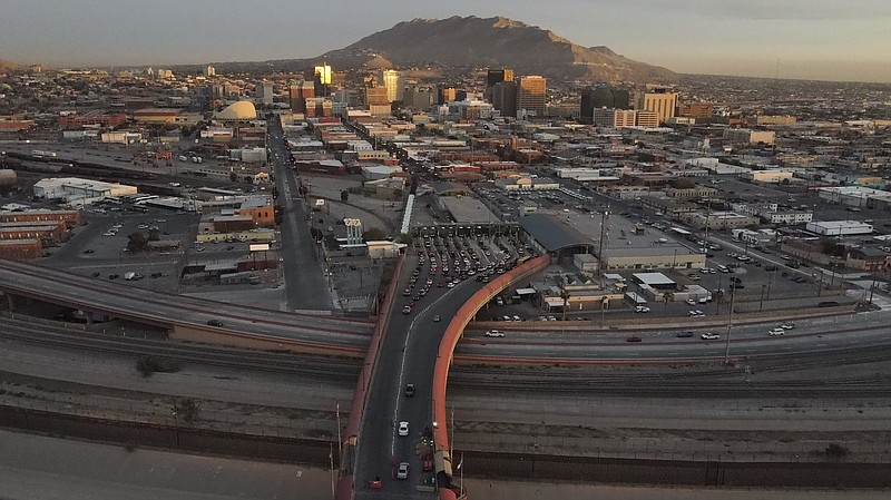 FILE - Cars line up at the Paso del Norte international bridge in Ciudad Juarez, Mexico, below, on the border with El Paso, Texas, top, Nov. 8, 2021. A large group of migrants in Mexico who were poised to barge into the U.S. over the weekend were blocked from crossing the bridge, a U.S. Customs and Border Protection spokesperson said. The migrants were “posing a potential threat to make a mass entry,” and physical barriers were put up to restrict their entry on Sunday afternoon, spokesperson Roger Maier said in a statement to The Associated Press on Monday, March 13, 2023. (AP Photo/Christian Chavez, file)