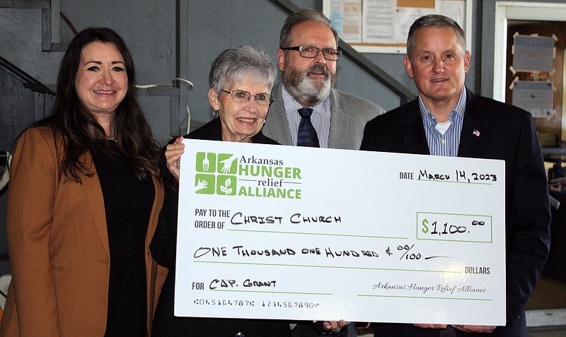 Camille Wrinkle of Harvest Regional Food Bank, from left, Linda Crawford, Lance Whitney of Arkansas Hunger Relief Alliance and Rep. Bruce Westerman pose as Crawford receives a $1,100 check to Christ Church of Texarkana on Tuesday, Mar. 14, 2023, at the food bank in Texarkana, Arkansas. (Staff photo by Mallory Wyatt)