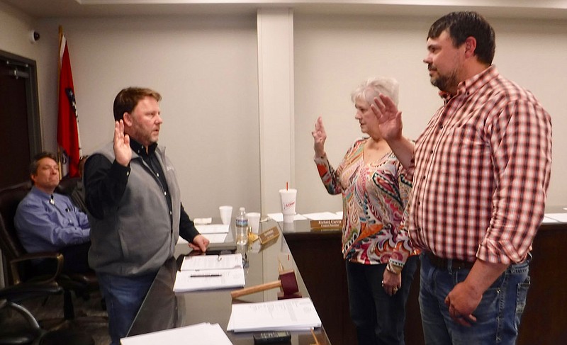 Susan Holland/Westside Eagle Observer Mayor Kurt Maddox swears in Jo Ellen Davis and Anthony Bertschy as new members of the Gravette Planning Commission at a special council meeting Tuesday evening, March 14. City Attorney Davis Bailey is visible in the background.