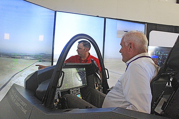 Robert Ator (right), director of military affairs for the Arkansas Economic Development Commission, flies an F-35 simulator in October 2021 as Cody Blake, cockpit demonstrator instructor pilot for Lockheed Martin, directs him at TAC Air in Fort Smith. The simulation tutorial was preceded by a talk from 3rd District Rep. Steve Womack, R-Rogers, about the Air Force’s selection for the Ebbing Air National Guard base to house up to 36 Lockheed Martin F-35 Lighting IIs and General Dynamics F-16 Fighting Falcons fighter jets for Foreign Military Sales and training.

(File Photo/River Valley Democrat-Gazette)