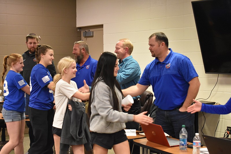 Democrat photo/Garrett Fuller — Girls present March 15 at the California R-I Board of Education meeting shake hands with board members after the members voted unanimously to add girls soccer programs to California's middle and high school.