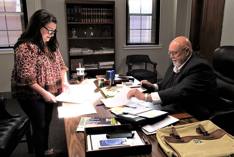City Clerk Heather McVay hands Mayor Paul Choate a stack of papers that requires the mayor's signature in this January 2023 News-Times file photo. Signing the papers was one of several tasks Choate handled his first week in office. (Tia Lyons/News-Times)
