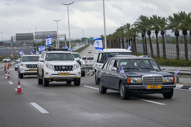 Cars drive with Israeli flags slowly as a protest against plans by Prime Minister Benjamin Netanyahu's government to overhaul the judicial system, ahead of Netanyahu's visit to Germany in Ben Gurion airport near Tel Aviv, Israel, Wednesday, March 15, 2023. Hundreds of Israeli writers, artists and intellectuals on Tuesday called on Germany and Britain to cancel upcoming visits by Prime Minister Benjamin Netanyahu, saying his plan to overhaul Israel's judicial system has put the country on a destructive course. (AP Photo/Tsafrir Abayov)