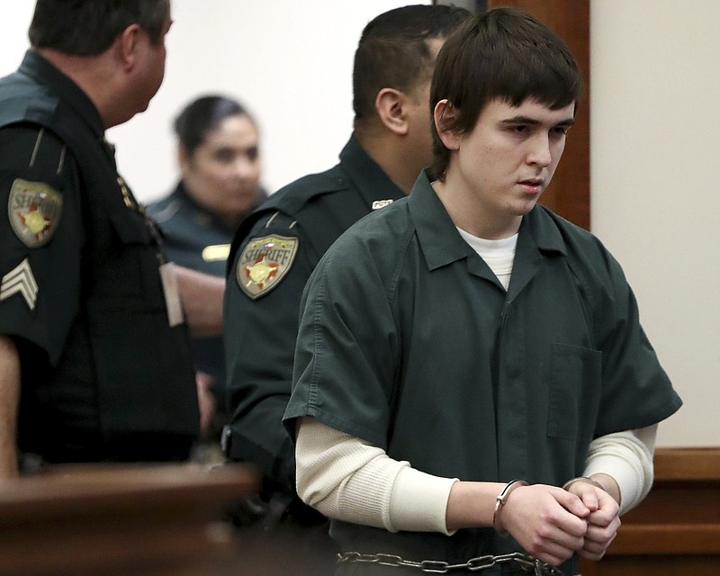 FILE - Dimitrios Pagourtzis is escorted by Galveston County Sheriff's Office deputies into a courtroom at the Galveston County Courthouse on Feb. 25, 2019, in Galveston, Texas. In a motion filed Tuesday, March 14, 2023, attorneys for Pagourtzis, accused of fatally shooting 10 people at a Texas high school in 2018, are seeking to have the judge handling the case removed, accusing him of bias for pushing to have experts deem the former student competent to stand trial. (Jennifer Reynolds/The Galveston County Daily News via AP, File)
