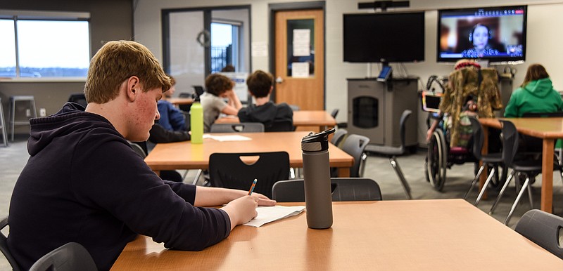 Julie Smith/News Tribune
Blair Oaks High School junior Burgess Sawyer takes notes as he listens to a video call by presenter Brittany Neier, who works as a training support analyst for the Federal Reserve Bank of St. Louis. Neier previously working in the zoological field, working at the St. Louis Zoo as an instructor in education, where she created and facilitated programs for all age groups. Sawyer intends to see a degree in business when he furthers his education after high school.