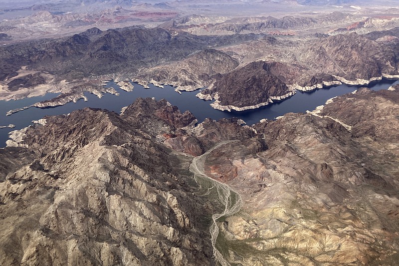 In this aerial photo, a bathtub ring of light minerals show the high water mark on the shore of Lake Mead along the border of Nevada and Arizona, Monday, March 6, 2023, near Boulder City, Nev. Climate experts say all the snow and rain over the winter months helped alleviate dry conditions in many parts of the western U.S., but the precipitation is nowhere near enough to unravel the long-term effects of a stubborn drought afflicting Lake Powell and Lake Mead. (AP Photo/John Locher)