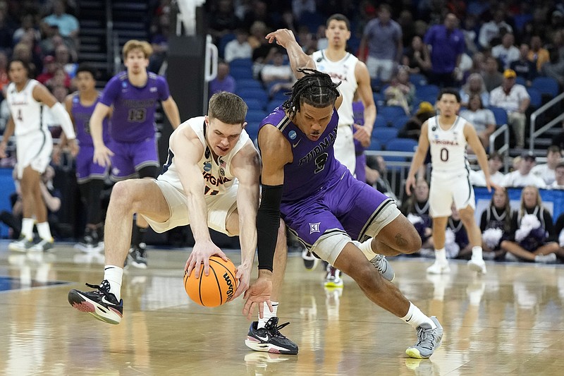 Virginia guard Isaac McKneely (11) and Furman guard Mike Bothwell (3) collide chasing a loose ball during the first half of a first-round college basketball game in the NCAA Tournament Thursday, March 16, 2023, in Orlando, Fla. (AP Photo/Chris O'Meara)