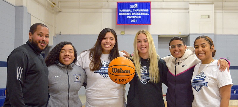 Champion Christian College head coach DeAnthony Ellison, left, stands with players Aaliyiah Clark, Kamryn Gentry, Tori Hayes, Justys Irish-Holmes and assistant coach Amalia Harris Wednesday. Champion Christian won the NCCAA DII national championship March 11. - Photo by Donald Cross of The Sentinel-Record