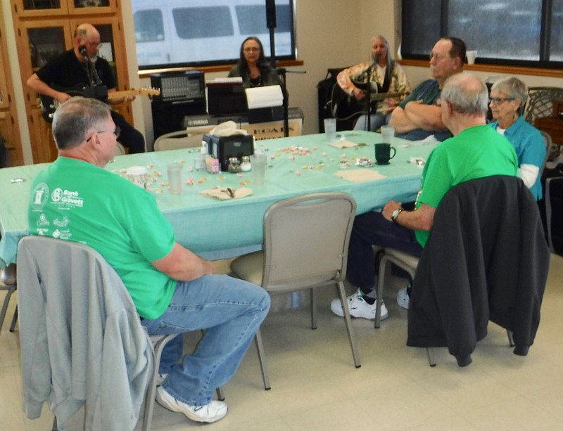 Susan Holland/Westside Eagle Observer
Guests at the Billy V. Hall Senior Activity Center enjoy visiting Friday, March 17, while listening to the members of the Prairie Roads Band. Several were dressed in green garments since Center director Melissa Provence had proclaimed it "Wear Green Day." Pictured at the table are Jack Kinney (left), Jerry August, Faye Gould and Jeff Mortensen.