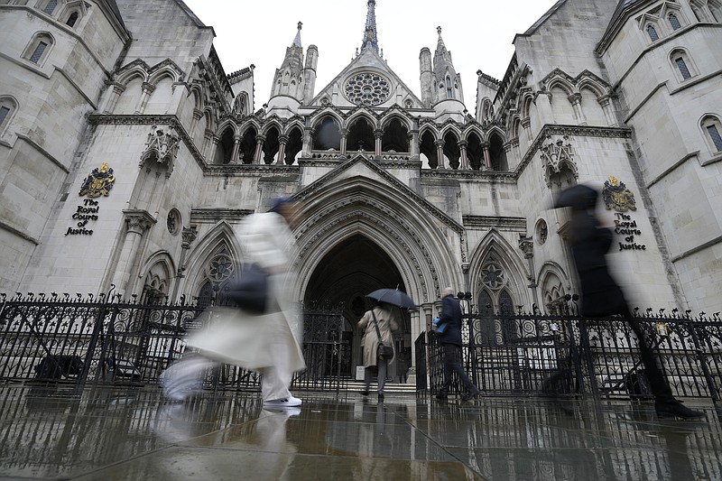 People walk past the Royal Court of Justice in London, Friday, March 17, 2023. The Duke of Sussex, Prince Harry is suing Associated Newspapers Limited (ANL) over an article about his separate judicial review proceedings against the Home Office regarding security arrangements for himself and his family when they are in the UK. (AP Photo/Frank Augstein)