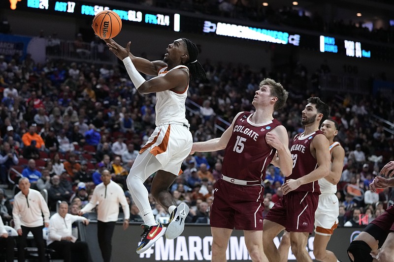 Texas guard Marcus Carr, left, drives to the basket past Colgate guard Tucker Richardson (15) in the second half of a first-round college basketball game in the NCAA Tournament, Thursday, March 16, 2023, in Des Moines, Iowa. (AP Photo/Charlie Neibergall)