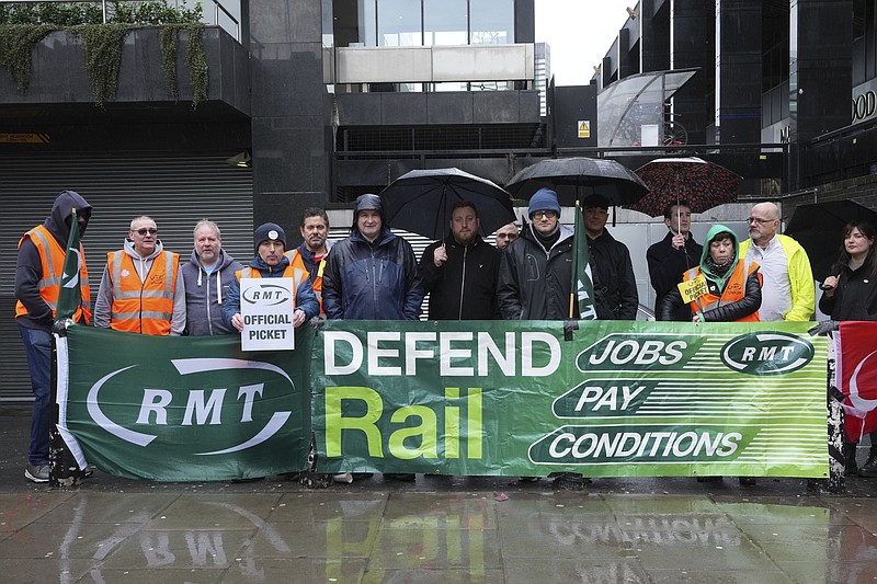 Mick Lynch, general secretary of the Rail, Maritime and Transport union (RMT), sixth left blue jacket, joins union members on the picket line during a rail strike in a long-running dispute over jobs and pensions, outside Euston station in London, Saturday March 18, 2023. Tens of thousands of teachers, doctors, health care workers, train drivers and civil servants have staged disruptive strikes in recent months to demand higher wages. (Jeff Moore/PA via AP)