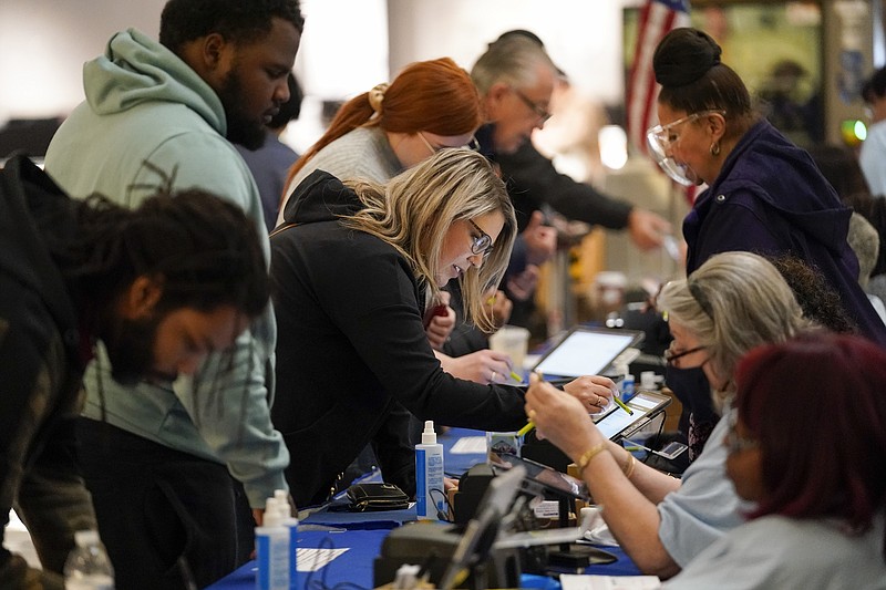 FILE - People check in to cast their votes at a polling station in a mall on Nov. 8, 2022, in Las Vegas. States enrolled in a bipartisan effort to ensure accurate voter lists plan to meet Friday, March 17, 2023, to consider whether changes are needed after three more Republican-led states announced plans to leave amid conspiracies fueled by false claims about the 2020 presidential election that have targeted the group. (AP Photo/Gregory Bull, File)