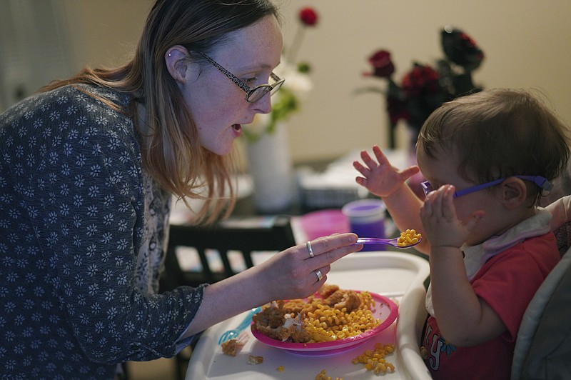 Lauren Hackney feeds her 1-year-old daughter chicken and macaroni during a supervised visit at their apartment in Oakdale, Pa., on Thursday, Nov. 17, 2022. Lauren and her husband, Andrew, wonder if their daughter’s own disability may have been misunderstood in the child welfare system. The girl was recently diagnosed with a disorder that can make it challenging for her to process her sense of taste, which they now believe likely contributed to her eating issues all along. (AP Photo/Jessie Wardarski)