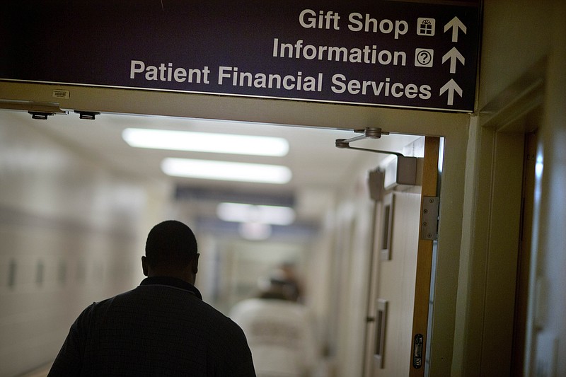 A sign points visitors toward the financial services department Friday, Jan. 24, 2014, at a hospital. Medicaid coverage will end for millions of Americans in 2023, and that pushes many into unfamiliar territory: the health insurance marketplace. (AP Photo/David Goldman, File)