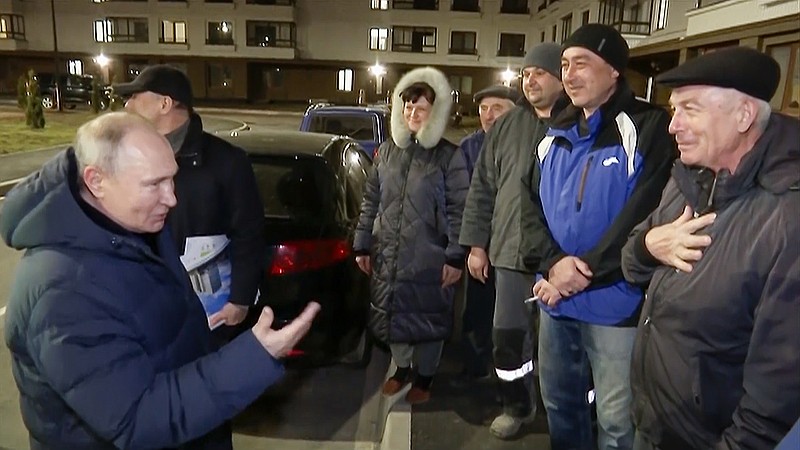 In this photo taken from video released by Russian TV Pool on Sunday, March 19, 2023, Russian President Vladimir Putin talks with local residents during his visit to Mariupol in Russian-controlled Donetsk region, Ukraine. Putin has traveled to Crimea to mark the ninth anniversary of the Black Sea peninsula's annexation from Ukraine. (Pool Photo via AP)