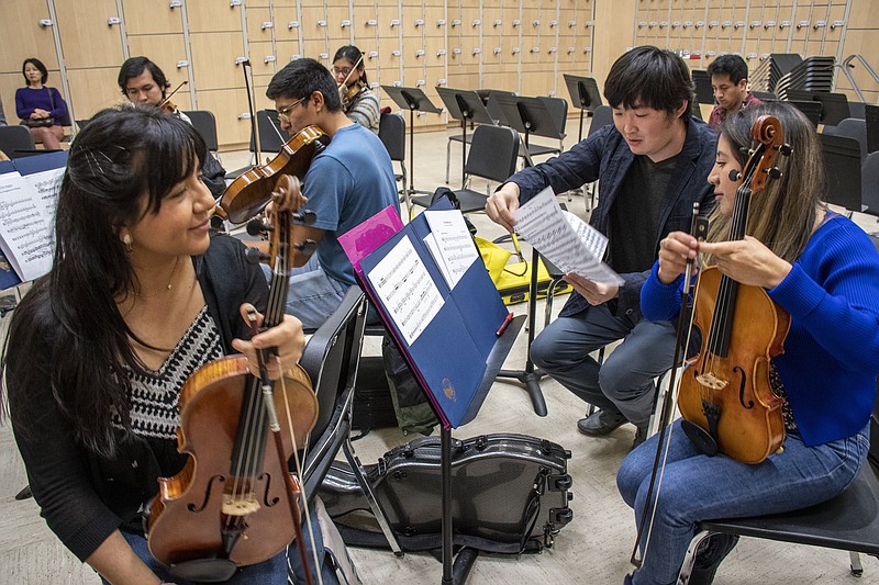 Tiezheng Shen (back right) talks to his Mexican viola students Maria Paulina Casa Gonzalez (left) and Elizabeth Calixto Munoz (right) before a rehearsal with other University of Central Arkansas students rehearse for an April 22 Conway Symphony Orchestra performance. Chinese violist Shen lives in Tucson, Ariz., and teaches classical viola music to the two students at UCA, his alma mater. (Arkansas Democrat-Gazette/Cary Jenkins)