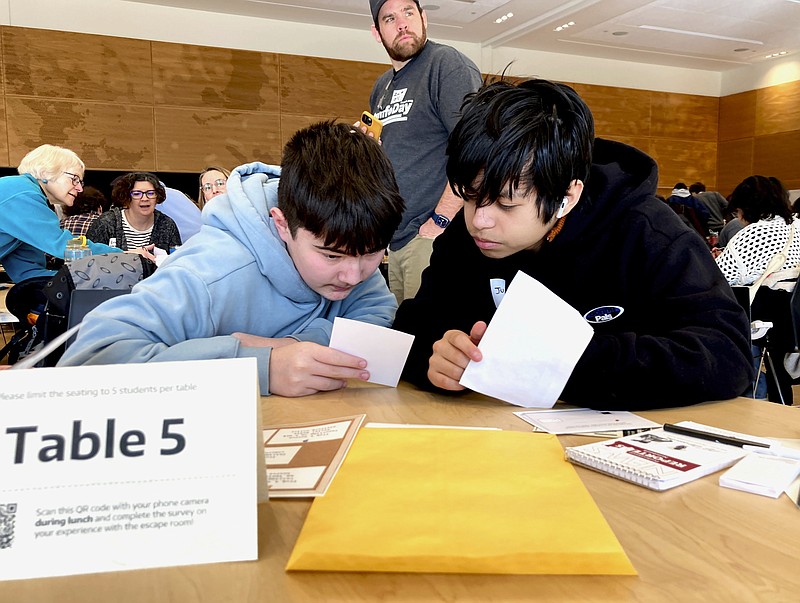 Meadowdale High School freshmen Juanangel Avila, right, and Legacy Marshall, left, work together to solve an exercise at MisinfoDay on Tuesday, March 14, 2023, in Seattle. The event hosted by the University of Washington to help high school students identify and avoid misinformation. Educators around the country are pushing for greater digital media literacy education. (AP Photo/Manuel Valdes)