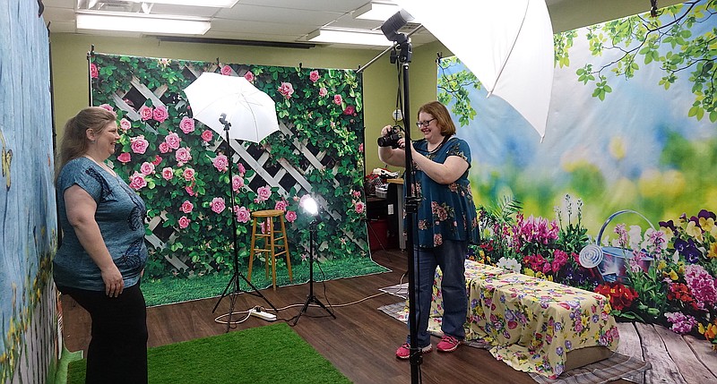Starr Ferrusquia is getting her own professional portrait made by Atlanta Public Library Librarian Kendra Harrell. Starr’s family will join her next. The service, she said, is an example of the benefit a local library provides for a town. (Photo by Neil Abeles)