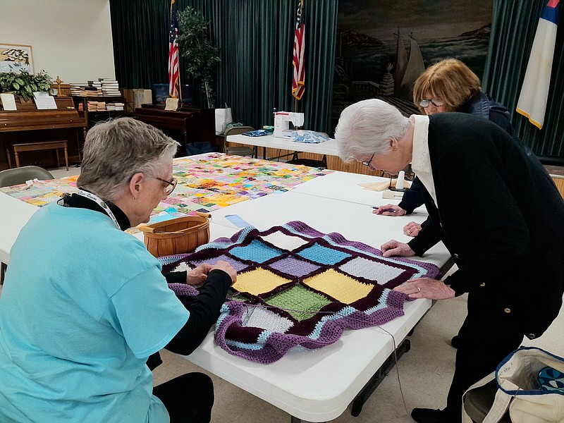 Grand Prairie Quilters check out the lap robe a member is making. (Special to The Commercial)