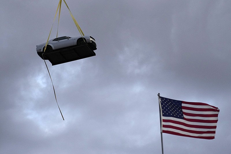 A helicopter transports the 2023 Challenger SRT Demon 170 during an event to unveil the car Monday, March 20, 2023, in Las Vegas. (AP Photo/John Locher)