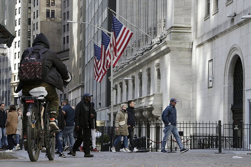 People pass the front of the New York Stock Exchange in New York, Tuesday, March 21, 2023. Stocks are rising on Wall Street, including the banks most beaten down by the industry's crisis. (AP Photo/Peter Morgan)