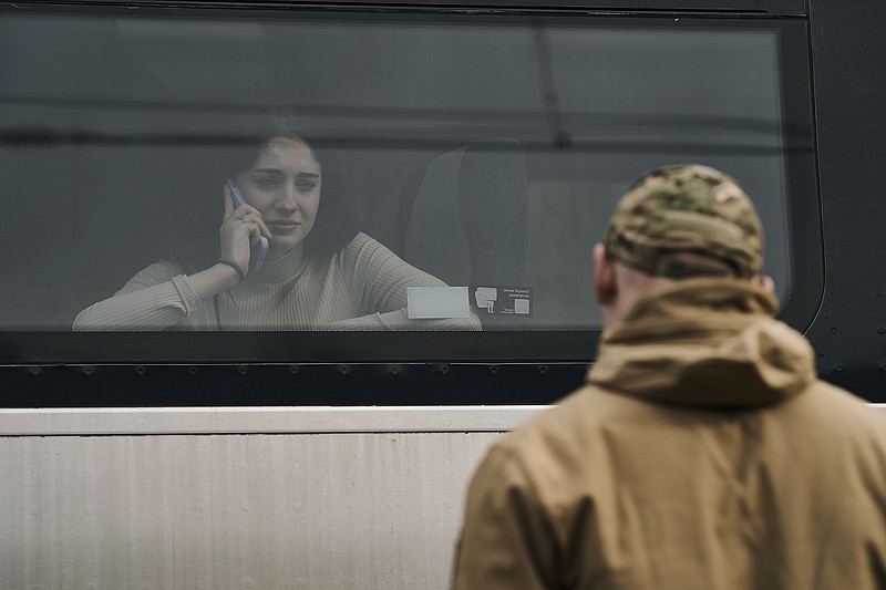 A Ukrainian soldier says goodbye to his wife as she takes a train at a railway station in Kramatorsk, Donetsk region, Ukraine, Tuesday, March 21, 2023. (AP Photo/Libkos)