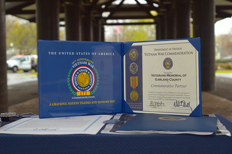 A display showing a commemorative certificate, presidential proclamation and several pins that will be provided to Vietnam veterans, their families and friends are shown at the Hot Springs Farmers and Artisans Market pavilion on March 21. - Photo by Donald Cross of The Sentinel-Record