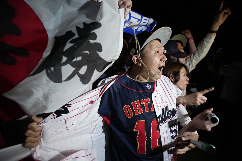 People celebrate Japan's victory against United States as they watch on a live stream of a World Baseball Classic (WBC) final being played at LoanDepot Park in Miami, during a public viewing event Wednesday, March 22, 2023, in Tokyo. (AP Photo/Eugene Hoshiko)