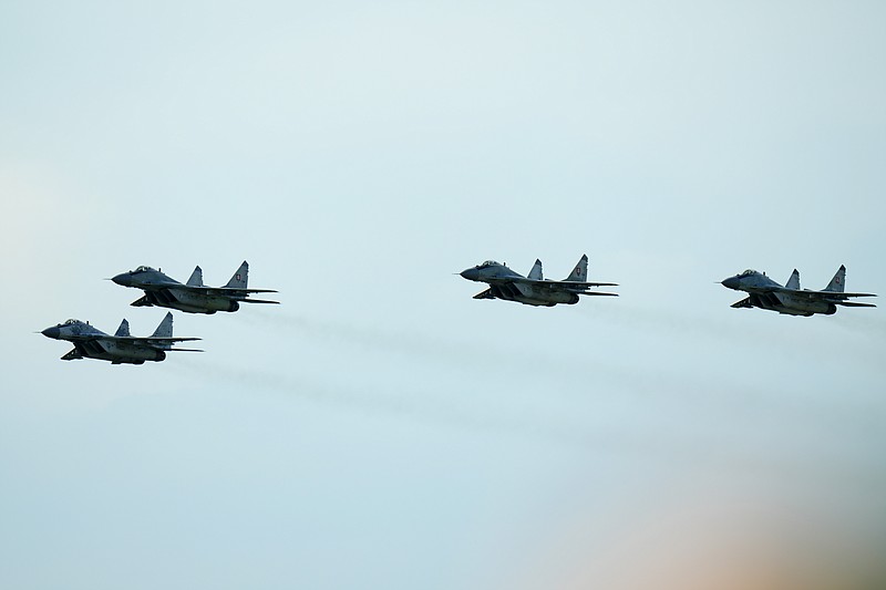 FILE - Slovak Air Force MiG-29s fly over an airport during an airshow in Malacky, Slovakia, on Aug. 27, 2022.  The first four of the 13 Soviet-era MiG-29 fighter jets that Slovakia decided to give Ukraine has been safely handed over to the Ukrainian air forces, the Slovak Defense Ministry said on Thursday. The ministry said the fighter jets were flown from Slovakia to Ukraine by Ukrainian pilots with the help from the Slovak air forces, Ukrainian personnel and others. (AP Photo/Petr David Josek, File)