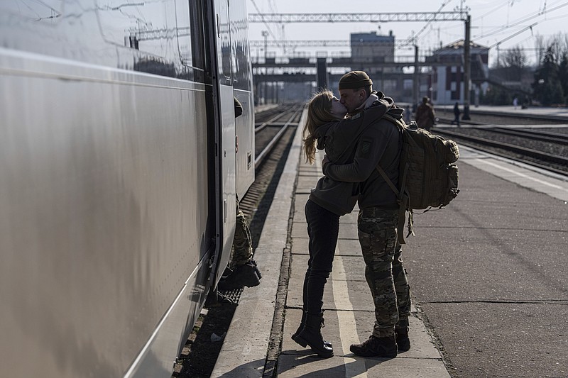 A Ukrainian serviceman kisses his partner at the train station in Kramatorsk, Ukraine, Thursday, March 23, 2023. (AP Photo/Evgeniy Maloletka)