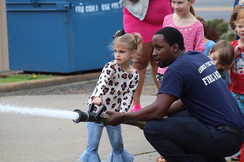 Photo By: Michael Hanich
Camden firefighter captain Qunicy White helps Delta Garner to use the fire hose during the Spring Break festivities.