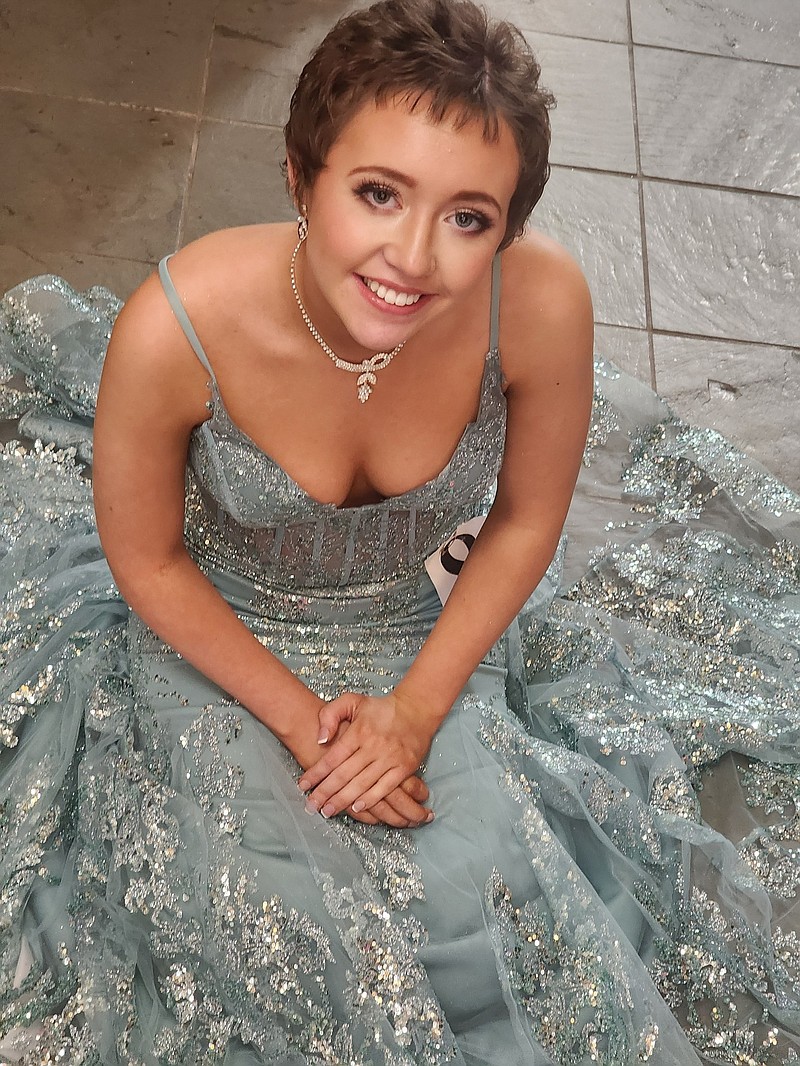 Lakyn Stroder sits in the dress she wore at the Miss Magnolia Blossom Pageant. (Photo Courtesy of Elaina Jones)