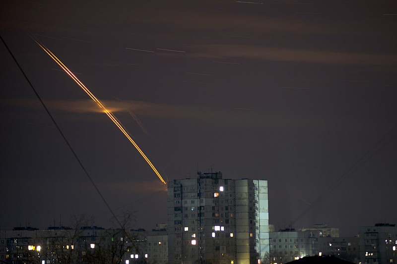 Russian rockets launched against Ukraine from Russia's Belgorod region streak across the sky at dawn in Kharkiv, Ukraine, early Friday, March 24, 2023. (AP Photo/Vadim Belikov)