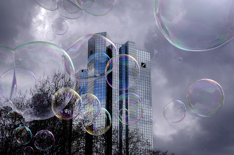 Bubbles made by a soap bubble artist, fly in front of the headquarters of Deutsche Bank in Frankfurt, Germany, Friday, March 24, 2023. (AP Photo/Michael Probst)