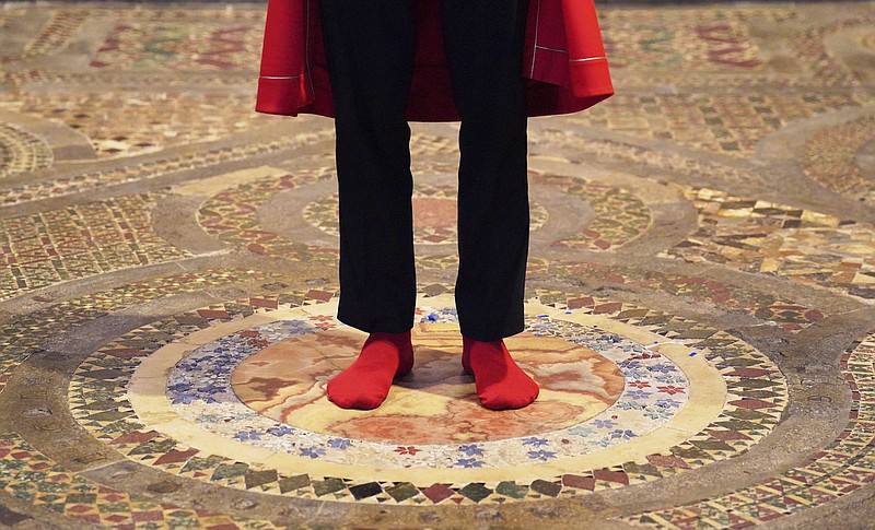 Abbey Marshal Howard Berry stands at the centre of the Cosmati pavement, located before the altar, during a photo call at Westminster Abbey, central London, to announce special events to celebrate the Coronation of King Charles III, Thursday March 23, 2023. Events at the Abbey will include barefoot tours of the Cosmati pavement, one of the UK's greatest medieval art treasures and the place of coronations for over 700 years and where the Coronation Chair will be placed to crown the King. (Jonathan Brady/PA via AP)