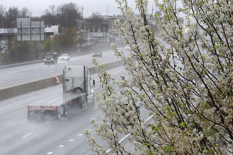 Traffic passes flowering trees Wednesday March 24 2023 along Interstate 49 on a rainy day in Rogers. Go to nwaonline.com/photos for today’s photo gallery. (NWA Democrat-Gazette/Flip Putthoff)