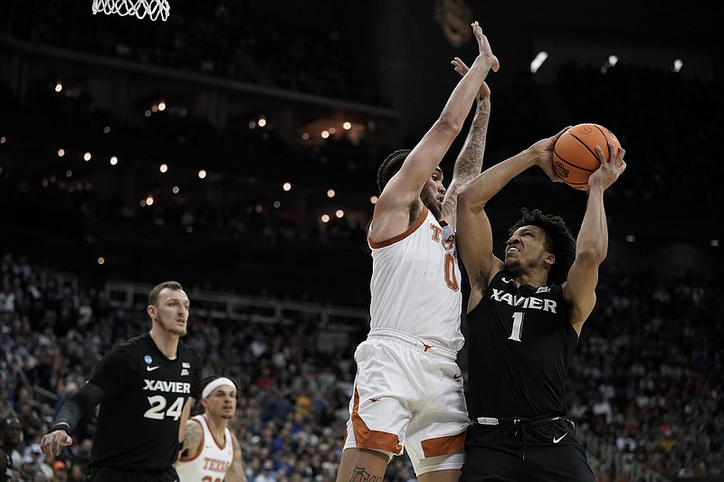 Xavier guard Desmond Claude shoots over Texas forward Timmy Allen in the first half of a Sweet 16 college basketball game in the Midwest Regional of the NCAA Tournament Friday, March 24, 2023, in Kansas City, Mo. (AP Photo/Charlie Riedel)