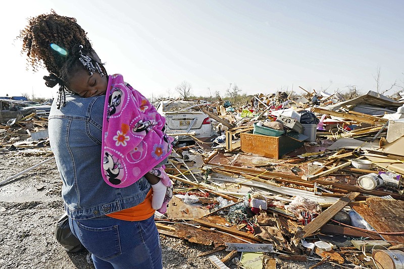 Wonder Bolden cradles her year-old grand daughter Journey Bolden as she surveys the remains of her mother's tornado demolished mobile home in Rolling Fork, Miss., Saturday, March 25, 2023.    Emergency officials in Mississippi say several people have been killed by tornadoes that tore through the state on Friday night, destroying buildings and knocking out power as severe weather produced hail the size of golf balls moved through several southern states. (AP Photo/Rogelio V. Solis)