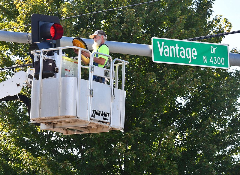 Brian Polingo, a traffic signal and signage technician with the Fayetteville's Transportation Division, replaces LED lights in a traffic signal Aug. 31 at Zion Road and Vantage Drive.

(File Photo/NWA Democrat-Gazette/Andy Shupe)