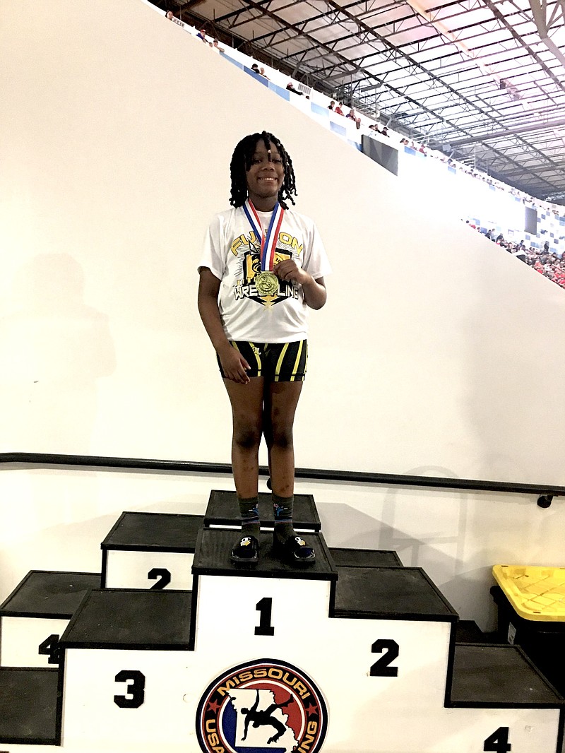 Era'Niq Knighten stands on the podium with her gold medal Saturday at Hy-Vee Arena in Kansas City. (Courtesy/Temetra Knighten)