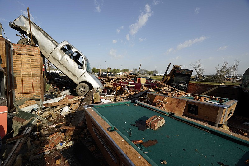 A pickup truck rests on top of a restaurant cooler at Chuck's Dairy Cafe in Rolling Fork, Miss., Saturday, March 25, 2023. 
   Emergency officials in Mississippi say several people have been killed by tornadoes that tore through the state on Friday night, destroying buildings and knocking out power as severe weather produced hail the size of golf balls moved through several southern states.  (AP Photo/Rogelio V. Solis)