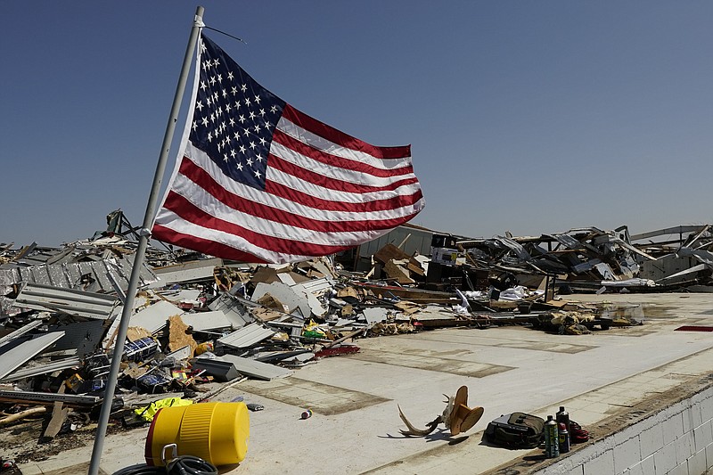 An American flag files on the slab of what was a hardware store in Rolling Fork, Miss., Saturday morning, March 25, 2023.  Emergency officials in Mississippi say several people have been killed by tornadoes that tore through the state on Friday night, destroying buildings and knocking out power as severe weather produced hail the size of golf balls moved through several southern states. (AP Photo/Rogelio V. Solis)