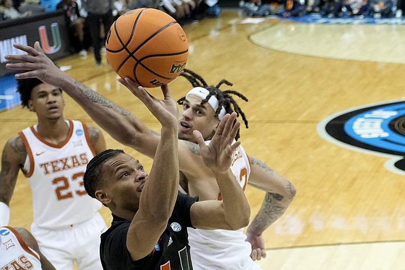 Miami guard Isaiah Wong shoots over Texas forward Christian Bishop in the first half of an Elite 8 college basketball game in the Midwest Regional of the NCAA Tournament Sunday, March 26, 2023, in Kansas City, Mo. (AP Photo/Jeff Roberson)