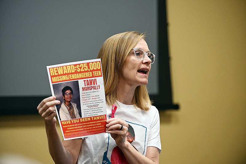 Jenny Wallace of Conway holds up a new flyer with the increased reward amount for missing teen Tanvi Marupally on Sunday during an event to honor Tanvi’s birthday at the Faulkner County Library in Conway.
(Arkansas Democrat-Gazette/Staci Vandagriff)