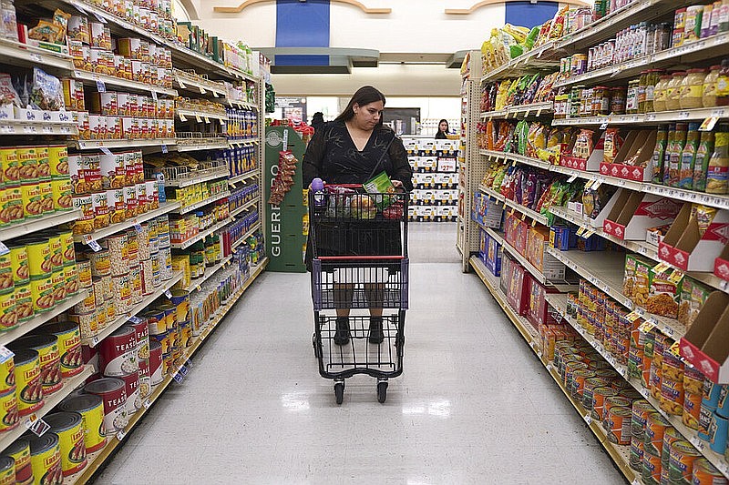 Jaqueline Benítez empuja su carrito por un pasillo mientras compra comestible en un supermercado en Bellflower, California, el lunes 13 de febrero de 2023. (AP/Allison Dinner).