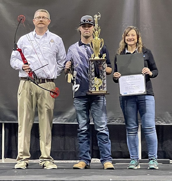 Courtesy/Missouri Department of Conservation
MDC Missouri National Archery in the Schools Program Coordinator Rob Garver, left, and Missouri Conservation Heritage Foundation Executive Director Tricia Burkhardt present a trophy for first place in the high school male division of the bull's-eye competition to Wyatt Basinger of Helias Catholic High School.