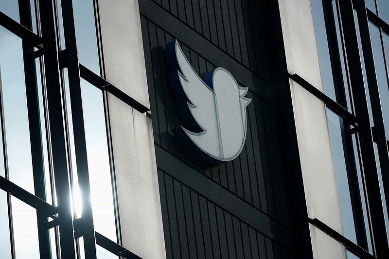 FILE - A Twitter logo hangs outside the company's offices in San Francisco, on Dec. 19, 2022. William Shatner, Monica Lewinsky and other prolific Twitter commentators &#x2014; some household names, others little-known journalists &#x2014; could soon be losing the blue check marks that helped verify their identity on the social media platform. (AP Photo/Jeff Chiu, File)