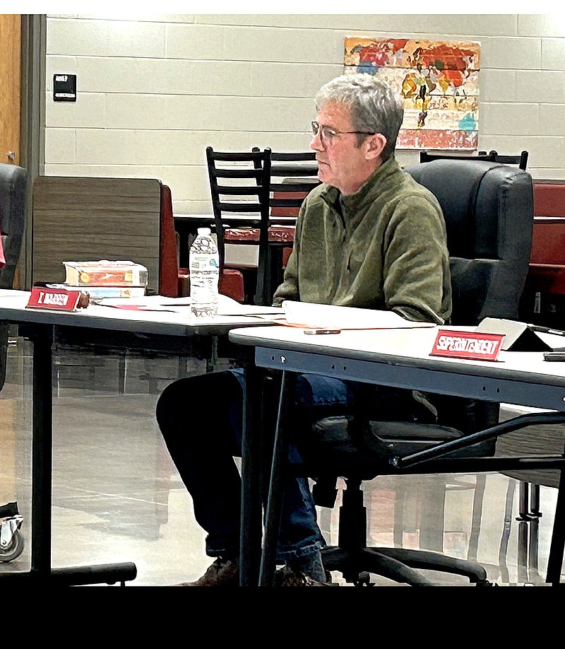 Lynn Kutter/Enterprise-Leader
Travis Warren, Farmington School Board president, discusses a challenge of two library books in the high school library. Warren has copies of both books on the table to his right. He said he read both books.
