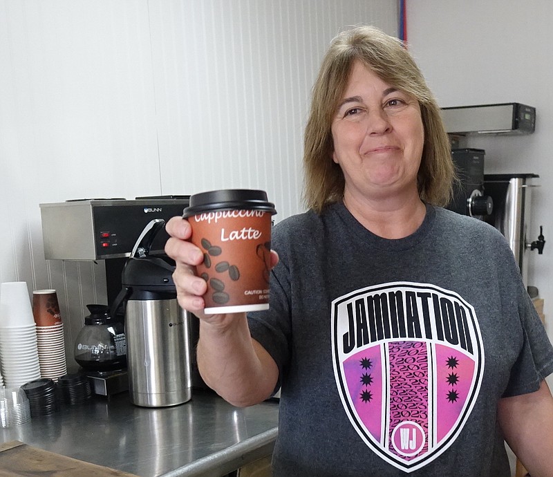“Here,” says Becca Thomas of her coffeehouse coffee now open in Linden. “I’ve made this my best. Let me know what you  think,” she might be saying. (Photo by Neil Abeles)